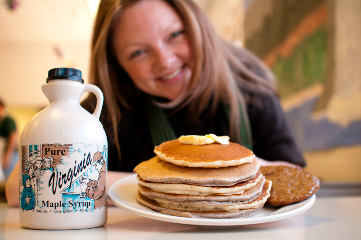 Woman with pancakes and maple syrup
