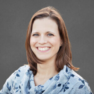 Smiling brunette woman on grey background