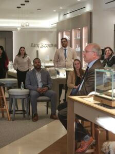 Prolfile of a man speaking with a small group of people