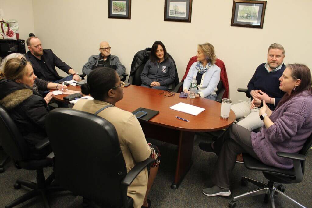 Group of people meeting around a large table.